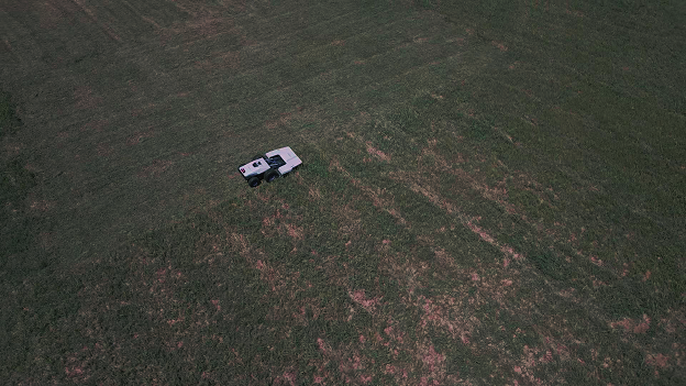 Distant view of the Pandag mower operating on the grass